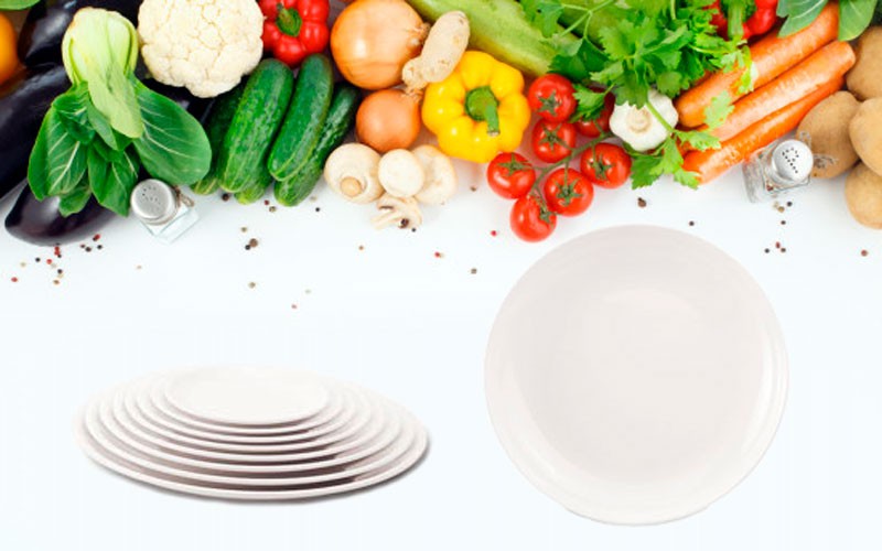 Круглые тарелки на фоне овощей