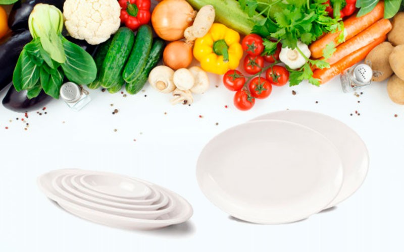 Овальные тарелки на фоне овощей